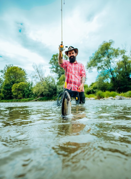 Photo man fishing and relaxing while enjoying hobby happy fisherman fishing in river holding fishing rods ...