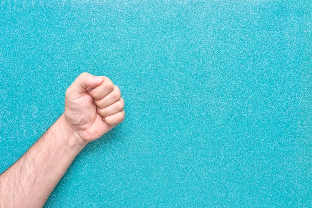 Man fist from corner with aquamarine color background