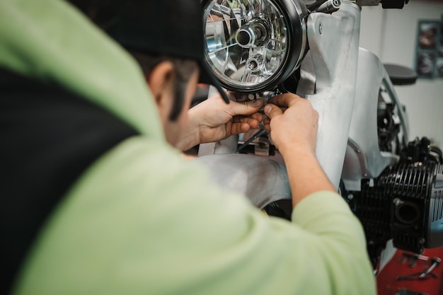 写真 現代のワークショップでバイクを修理する男