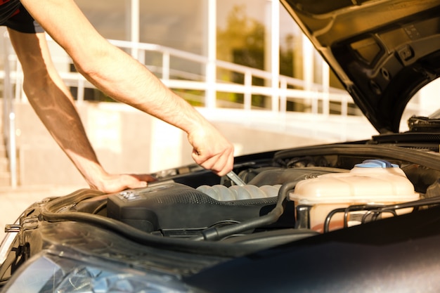 Man fixing engine. Car inspection. Work of mechanic