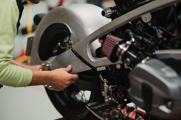 Man fixing a motorcycle in a modern workshop