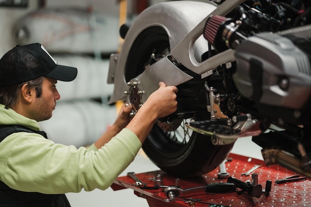 Man fixing a motorcycle in a modern workshop