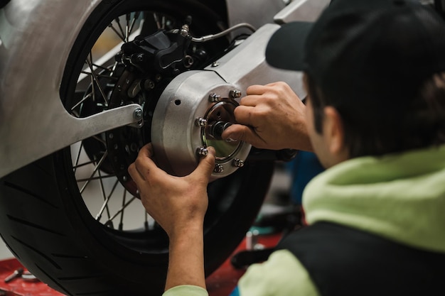 Man fixing a motorcycle in a modern workshop