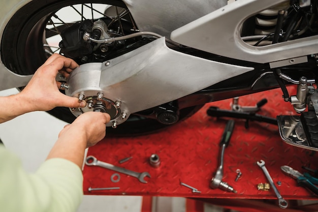 Man fixing a motorcycle in a modern workshop