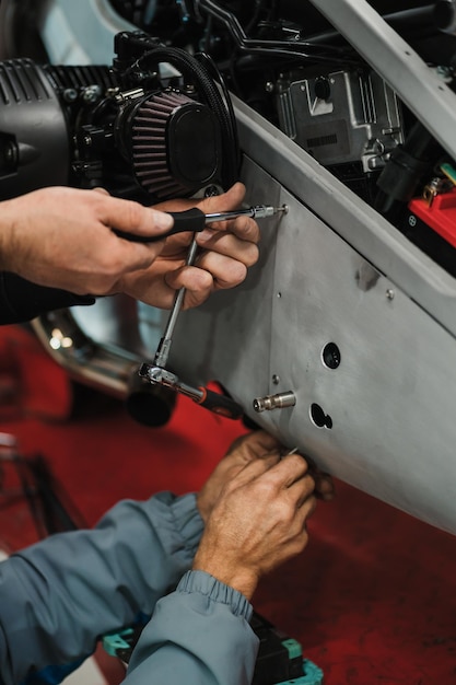 Photo man fixing a motorcycle in a modern workshop