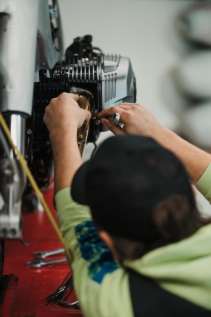 Photo man fixing a motorcycle in a modern workshop