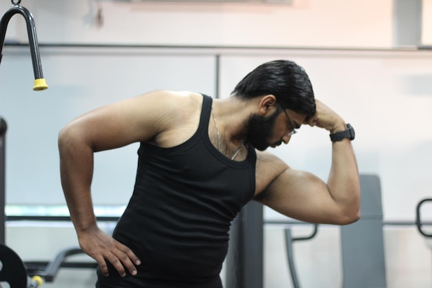 Photo man flexing muscles at gym