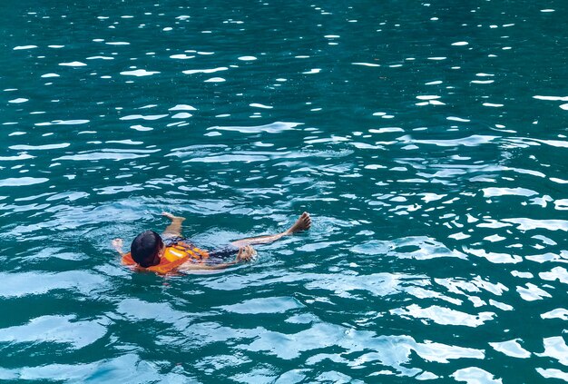 Un uomo che galleggia e si rilassa dall'immersione subacquea del mare all'isola di phi phi.