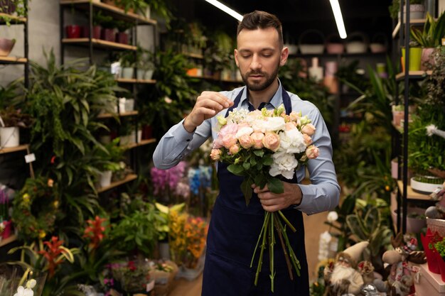 手にバラの花束を持った男性の花屋ahahは販売コンセプトの休日のために花を準備します