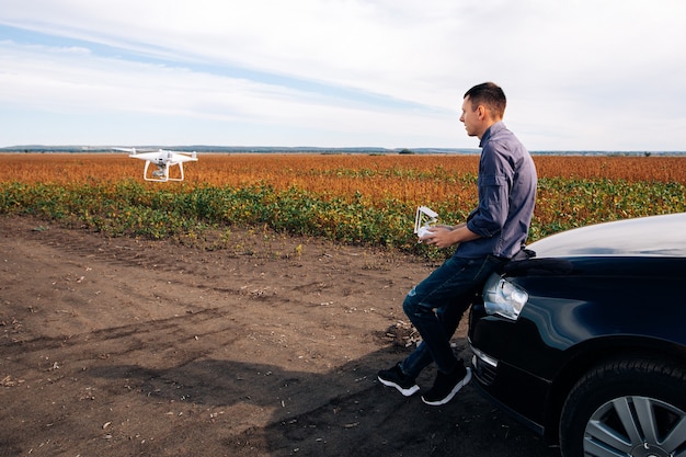 Man flying a drone in the yellow field