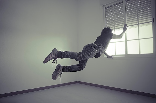 Photo man flying into a window, concept of freedom and imagination