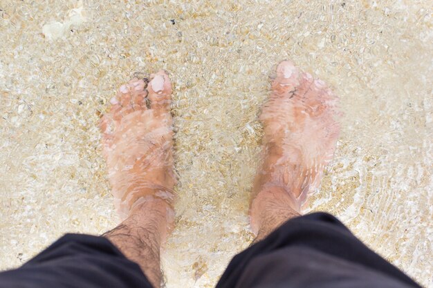 Foto piede uomo nel mare acqua