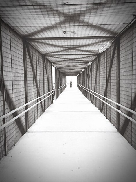 Foto uomo sul ponte pedonale