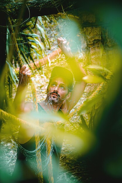 Photo man in forest seen through net