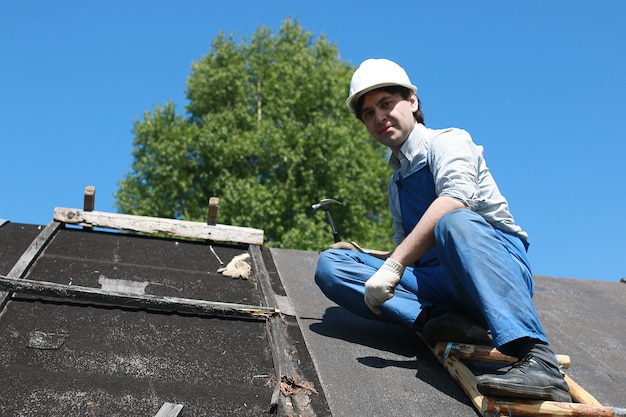 Photo a man in the form of a builder repairs a house