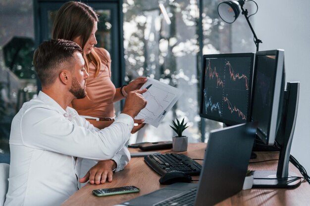 Man in formal clothes is with woman in the office