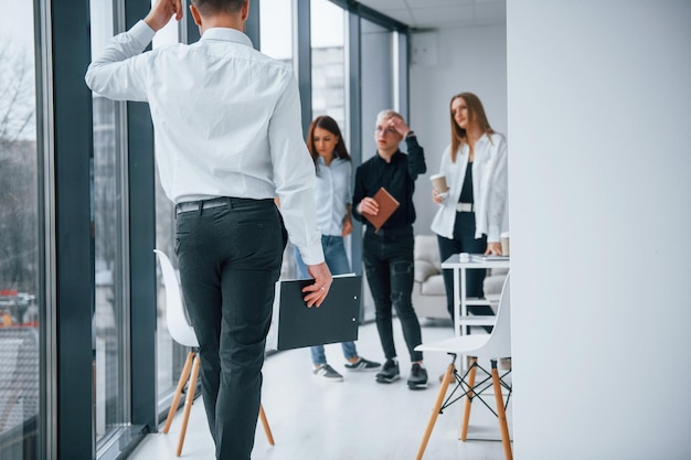 공식적인 옷을 입고 걷고 말하는 남자 사무실에서 함께 일하고 의사 소통하는 젊은 성공적인 팀 그룹