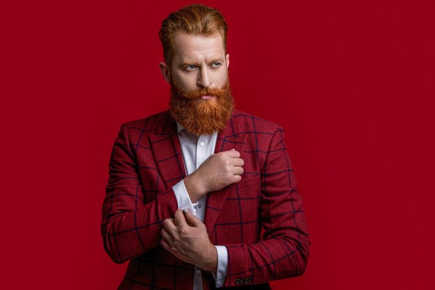 Man in formalwear suit isolated on red man in formalwear suit at studio man in formalwear suit on background photo of man in formalwear suit with beard