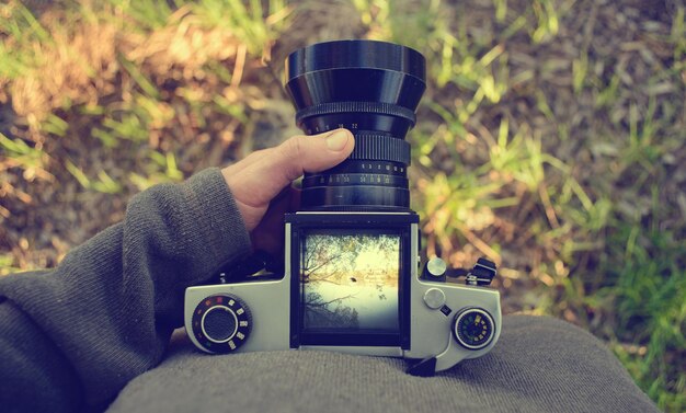 Man fotograaf maakt landschapsfotografie met oude filmcamera in de lente of zomer toerisme en wandelconcept bovenaanzicht kopieerruimte