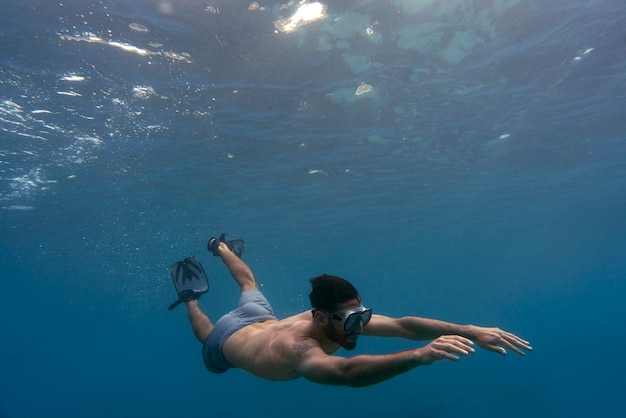 Foto uomo in apnea con pinne sott'acqua