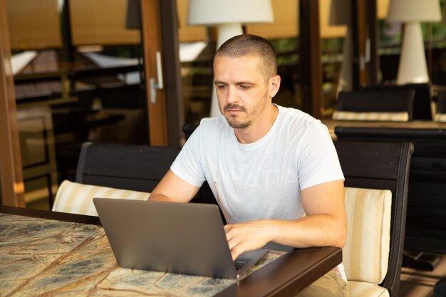 Man freelancer aan het werk in restaurant of café op zijn laptop. Externe werker