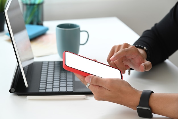 A man freelancer using mobile phone with blank screen for graphics display montage.