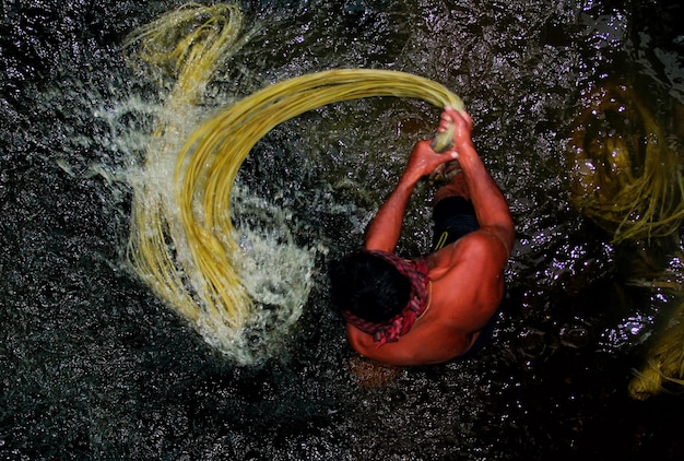 A man from the village is washing jute in the water