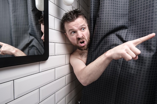 Man furious peeking out from behind shower curtain he caught\
someone peeping, yells angrily