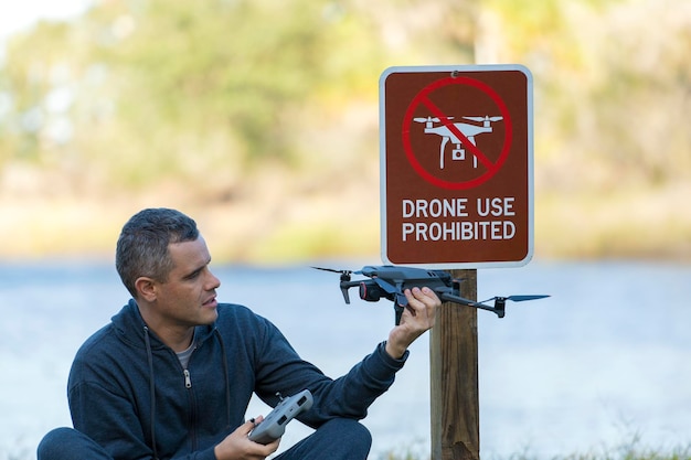 Man gaat zijn quadcopter vliegen in geen drone gebied Operator illegaal het gebruik van zijn UAS in het staatspark in de buurt van de beperking teken