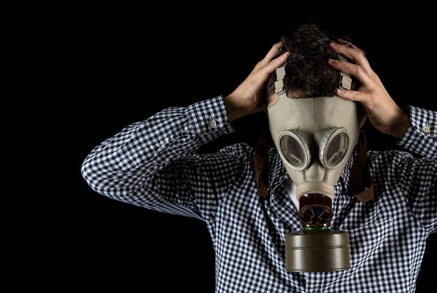 A man in a gas mask is worried about the current situation