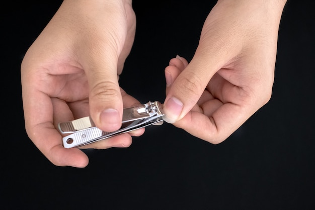 Foto man gebruik nagelknipper snijden hun duimen nagel