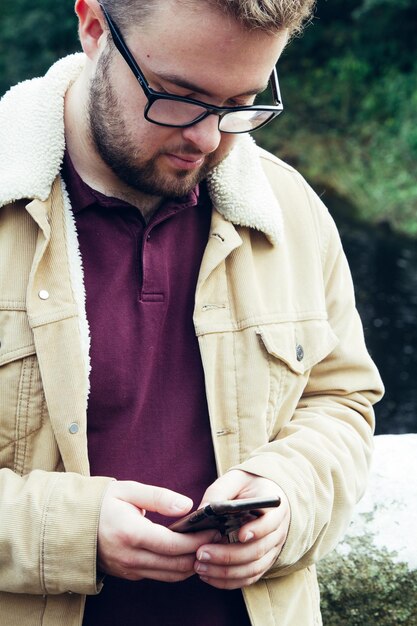 Man gebruikt mobiele telefoon terwijl hij buiten staat