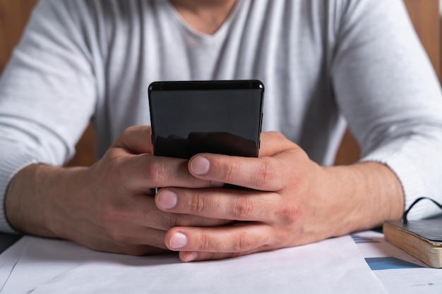 Man gebruikt smartphone op werkuren Concept van mobiele verslaving