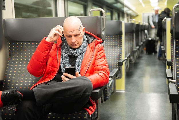 Foto man gebruikt telefoon terwijl hij in de trein zit