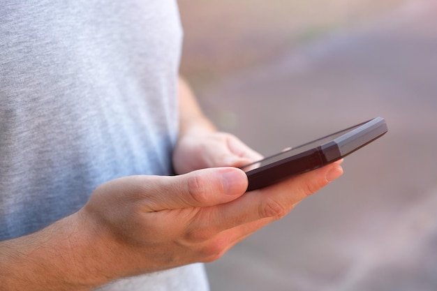 Man gebruikt zijn mobiele telefoon buitenshuis close-up