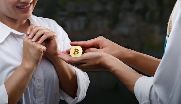 Man geeft hart als Bitcoin btc crypto-valuta om vrouw voor te stellen om te trouwen concept Love Bit munt en huwelijksleven Gouden medaille in palm als diamanten ring