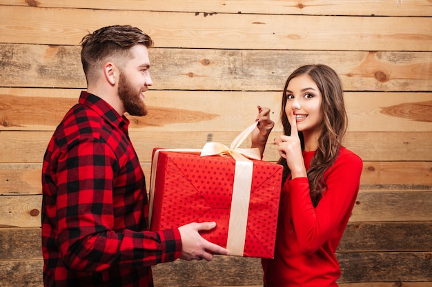 Man geeft rode geschenkdoos aan vrouw