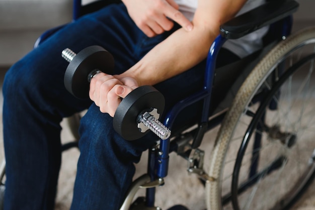 Man gehandicapte sport voor gehandicapte man in rolstoel met halters in handen man met halters in handen vader gehandicapt doen spotten sport op appartement gezondheid concept gezonde levensstijl