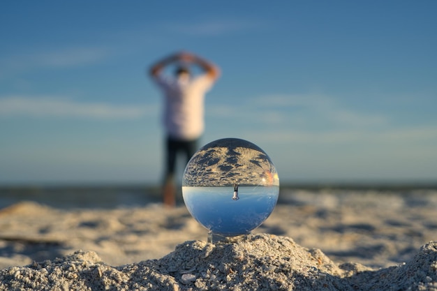 Foto man geniet van vrijheid op het strand van sanibel island genomen door een glazen bal