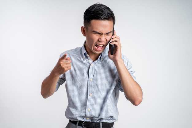 Man geschokt en boos tijdens het praten op zijn smartphone