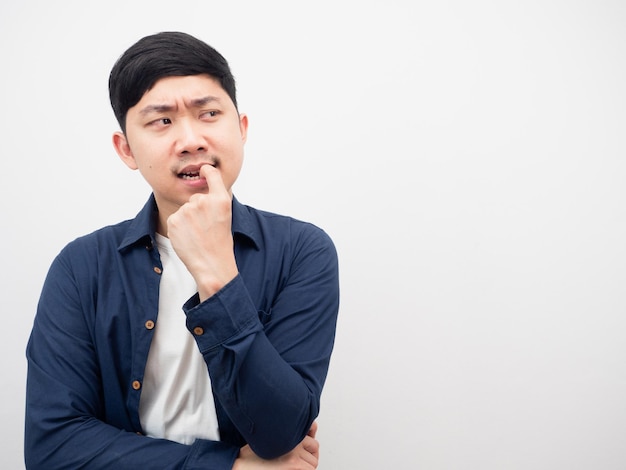 Man gesture biting nails feeling serious and thinking something looking at copy space