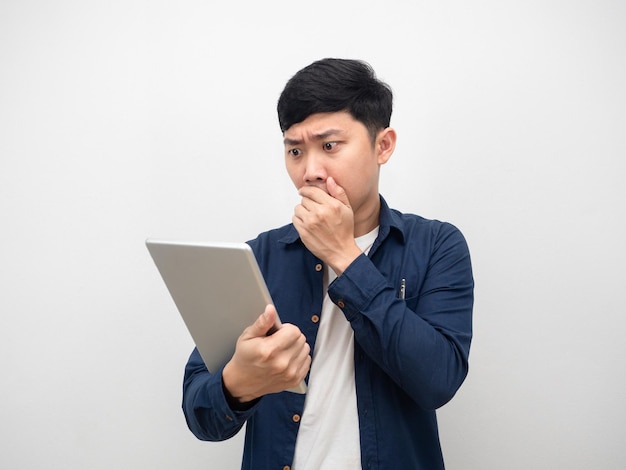 Man gesture close mouth looking at tablet in hand feeling shocked