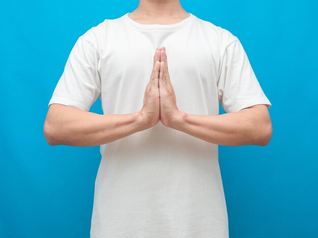 Man gesture respect hand crop shot blue background