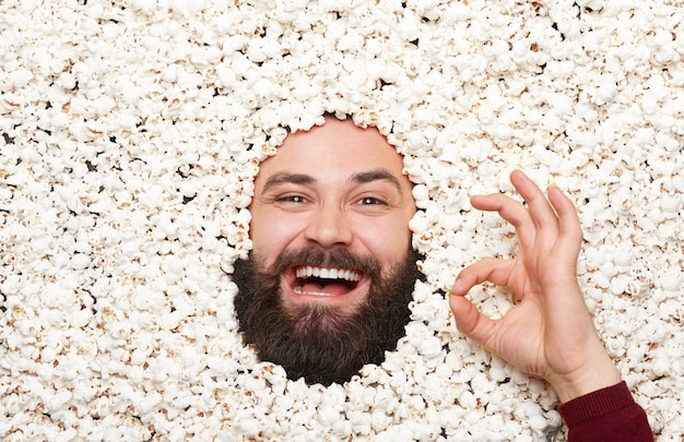 Foto uomo che gesticola in popcorn