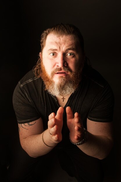 Man gesturing while standing against black background