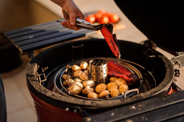 Man get out of the grill prepared vegetables