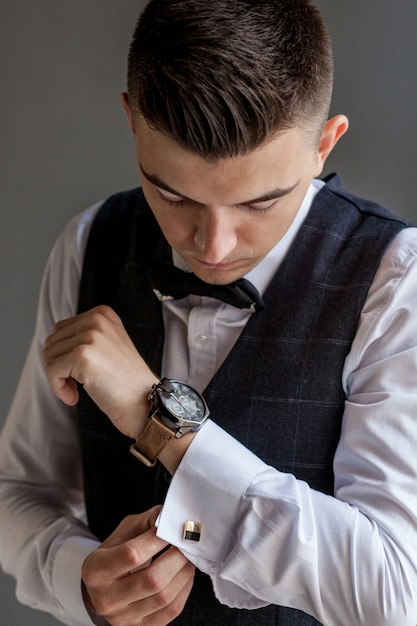 Man gets ready for work by buttoning up his business shirt. Groom's morning preparation before wedding