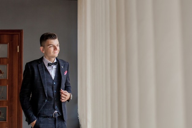 Man gets ready for work by buttoning up his business shirt. Groom's morning preparation before wedding