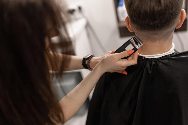 Man getting his hair cut at the back of his head with a clipper