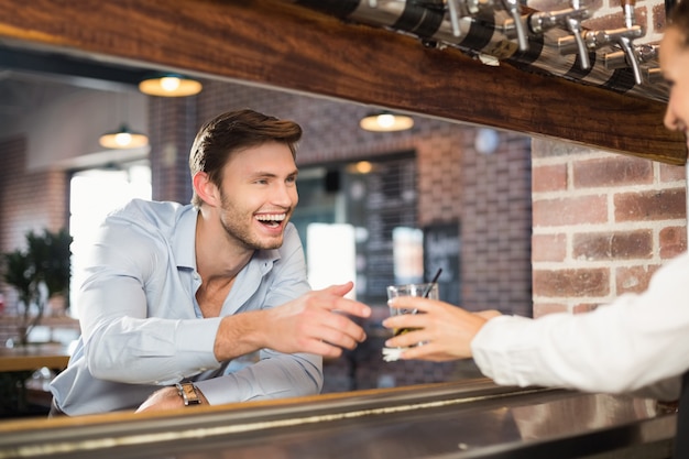 Man getting his order from barmaid